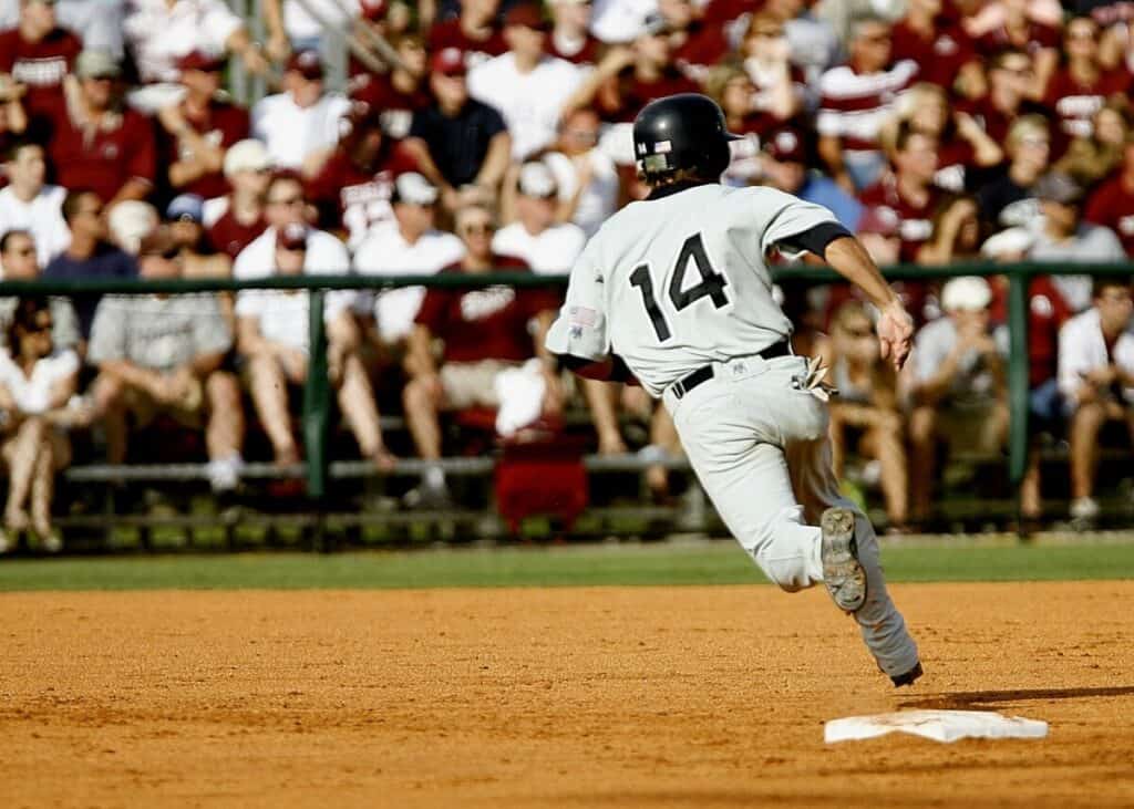 Baseball player wearing number 14 rounding second base