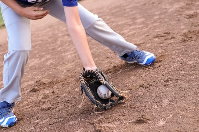 Closeup of a player who just fielded a baseball and the baseball is still in their glove