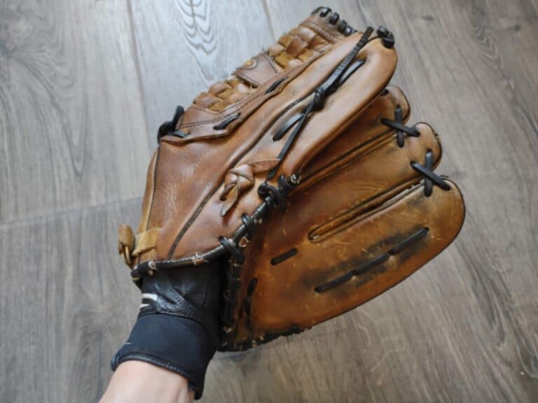 Closeup of a hand demonstrating how to wear a batting glove under a fielding glove