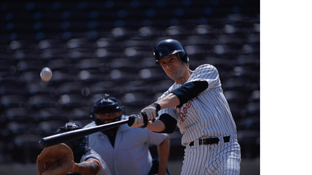 A right-handed hitter in a pinstripe uniform making contact with a pitch with the catcher and umpire in the background