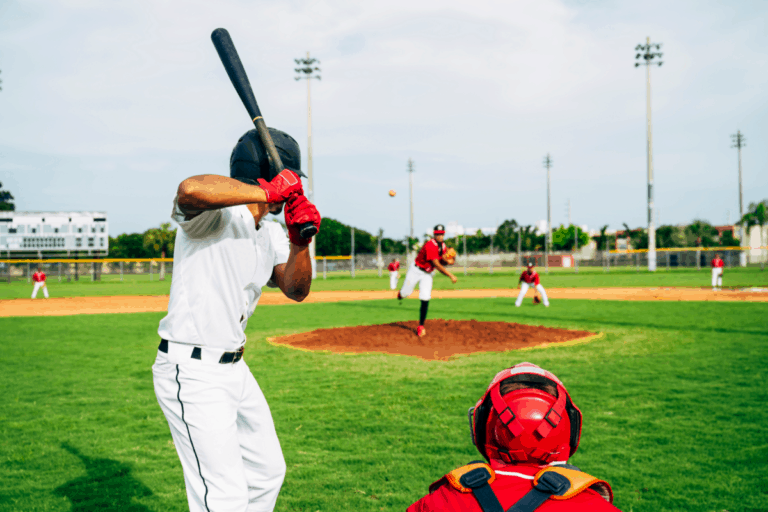 From the umpire's view, the pitcher in red just released the ball and the hitter in white is preparing to swing