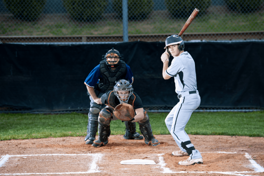 A pitcher's view of a hitter taking their stance, a catcher ready to catch the pitch, and an umpire who is ready to call the play