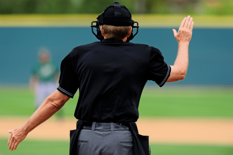 Backside view of an umpire signaling for time
