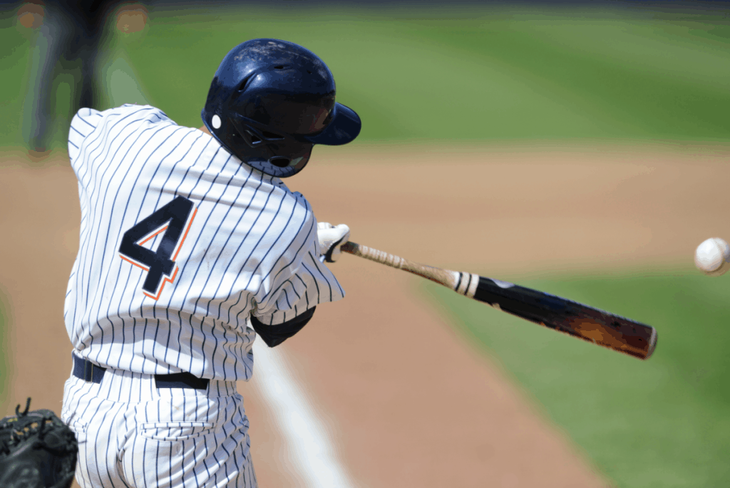 Backside view of a player in a pinstripe uniform who just made contact with a pitch