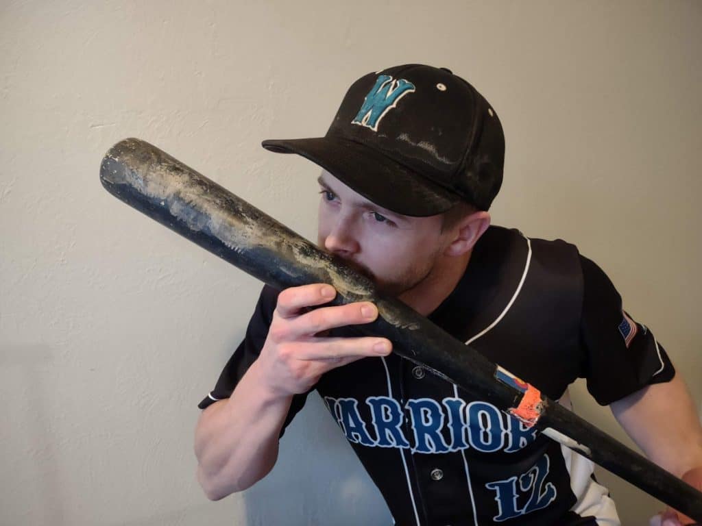 Baseball player smelling his wood bat