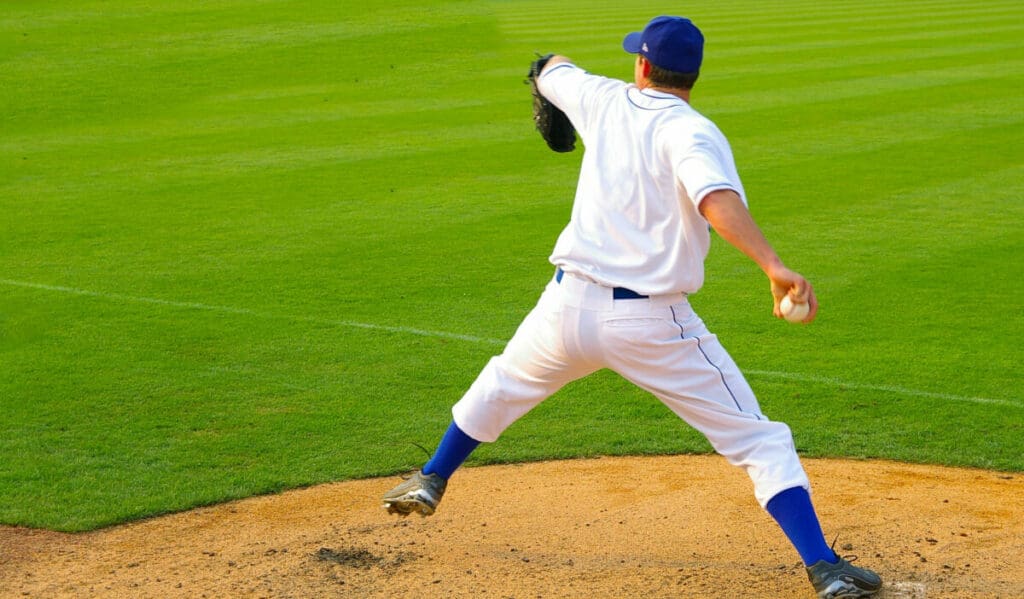 A pitcher in the bullpen stepping toward the catcher to deliver the next pitch