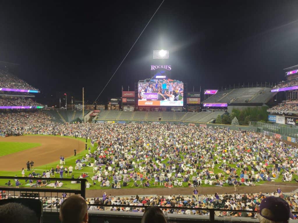 Colorado Rockies fans cover the outfield while waiting to see the fireworks show after the baseball game in 2021