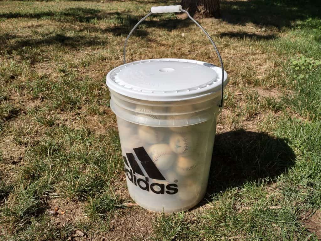 A 5-gallon plastic adidas bucket filled with baseballs and sealed with lid