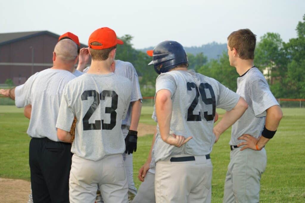 Baseball Coach talking to players near the pitcher's mound during practice