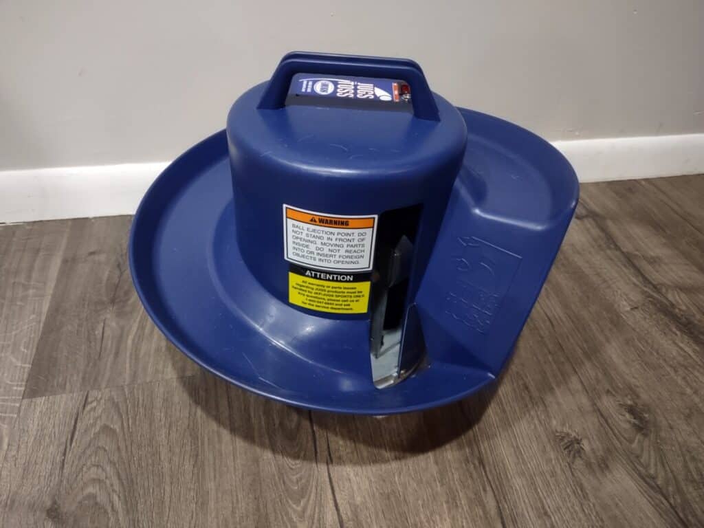 Closeup of a Jugs Toss Machine resting on a wood floor