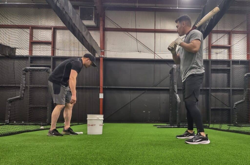 Thrower and hitter getting into position for soft toss drill
