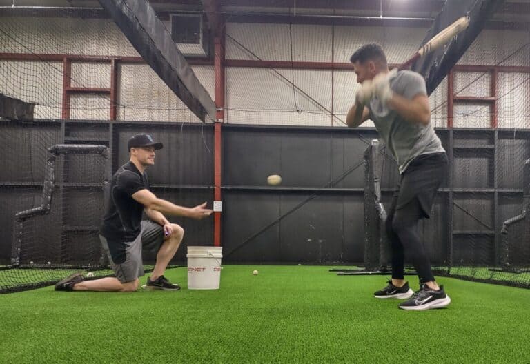 Pitcher lobs the soft toss pitch underhand and over the plate and the hitter prepares to swing