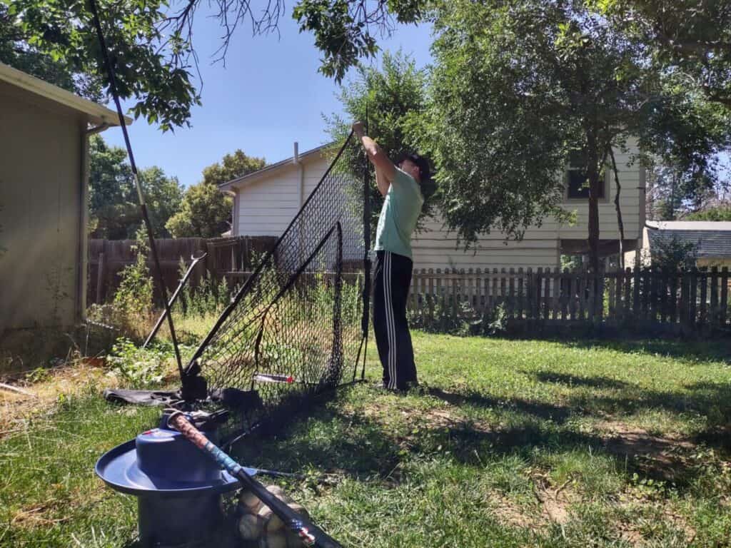 Steve Nelson setting up a hitting net in the backyard