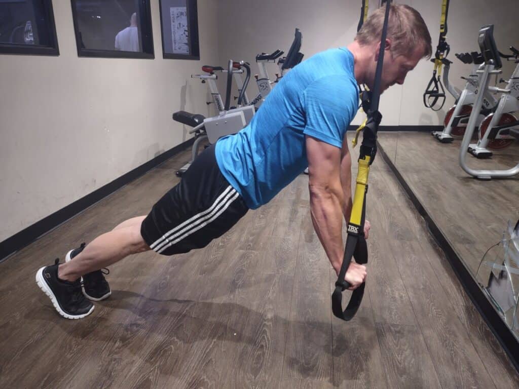 Steve Nelson at the starting position of a pushup while using TRX bands